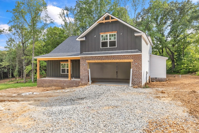 1586 Ryes Chapel Rd, Southside, TN 37171 - view of front of property with board and batten siding, covered porch, gravel driveway, an attached garage, and a shingled roof