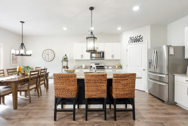 4043 Beach Way, White House, TN 37188 - kitchen featuring stainless steel appliances, a chandelier, pendant lighting, dark wood-style floors, and a breakfast bar area