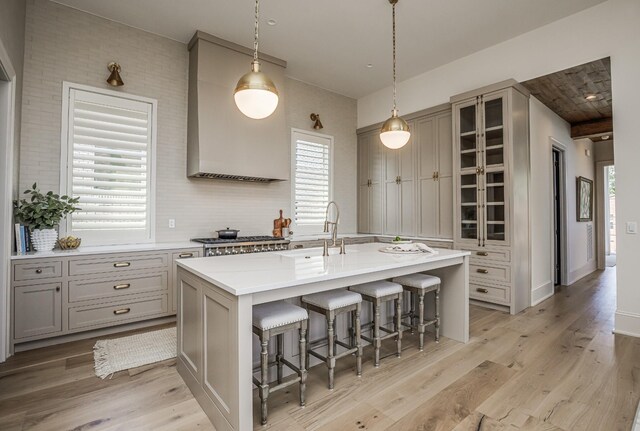 1302 Pillow St, Nashville, TN 37203 - kitchen featuring a kitchen bar, a sink, light wood finished floors, light countertops, and a center island with sink