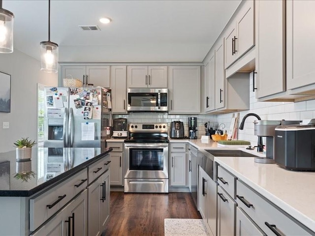 401 Queen Ln, Gallatin, TN 37066 - kitchen with stainless steel appliances, a sink, tasteful backsplash, dark wood-style floors, and decorative light fixtures