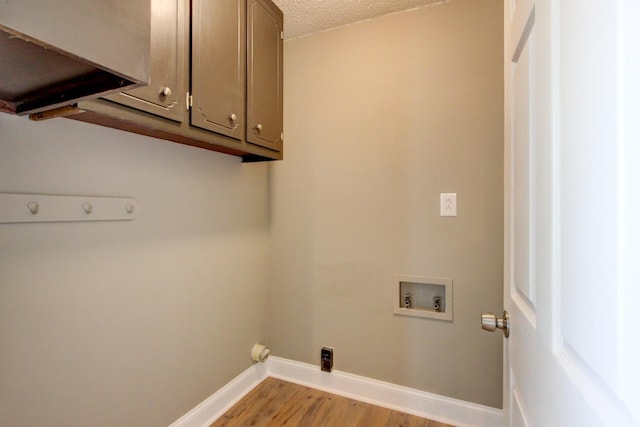 1783 Forrestdale Dr, Clarksville, TN 37042 - laundry room with washer hookup, light wood-style flooring, baseboards, cabinet space, and a textured ceiling