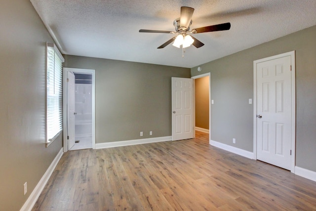 1783 Forrestdale Dr, Clarksville, TN 37042 - unfurnished bedroom with wood finished floors, a textured ceiling, baseboards, a ceiling fan, and connected bathroom