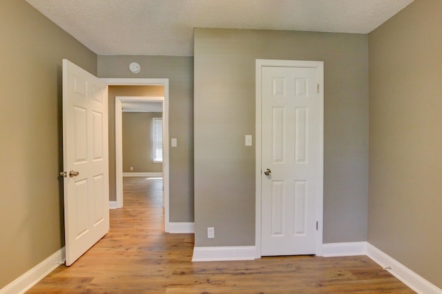 1783 Forrestdale Dr, Clarksville, TN 37042 - unfurnished bedroom with light wood finished floors, baseboards, and a textured ceiling