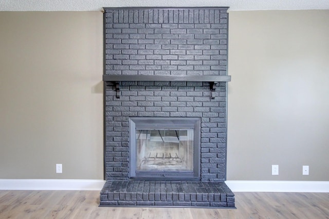 1783 Forrestdale Dr, Clarksville, TN 37042 - detailed view of baseboards, wood finished floors, a textured ceiling, and a brick fireplace