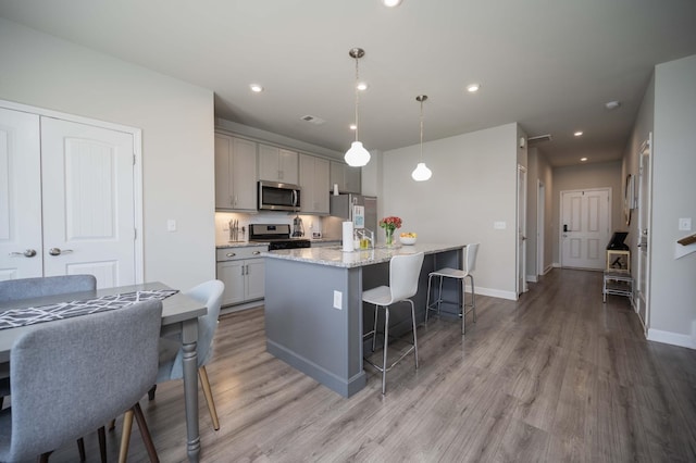 430 Burnley Way, Murfreesboro, TN 37128 - kitchen featuring stainless steel appliances, gray cabinetry, a breakfast bar, light wood-style floors, and an island with sink