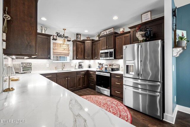 569 Station Circle Cir, Tullahoma, TN 37388 - kitchen with stainless steel appliances, a sink, dark brown cabinets, backsplash, and dark wood-style flooring