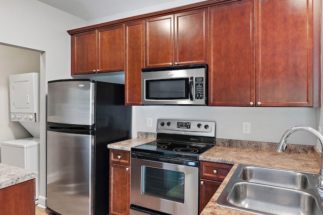 8221 Lenox Creekside Dr Unit 10, Antioch, TN 37013 - kitchen featuring stainless steel appliances, stacked washing machine and dryer, a sink, and light countertops