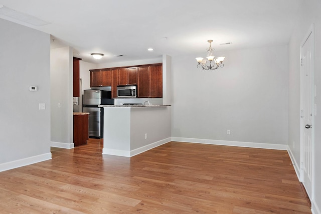 8221 Lenox Creekside Dr Unit 10, Antioch, TN 37013 - kitchen with stainless steel appliances, a chandelier, light wood-style floors, baseboards, and pendant lighting