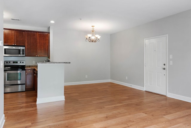 8221 Lenox Creekside Dr Unit 10, Antioch, TN 37013 - kitchen with appliances with stainless steel finishes, a chandelier, light wood-type flooring, baseboards, and recessed lighting