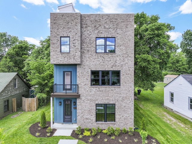 712 N 5th St, Nashville, TN 37207 - view of front of house with a balcony, a front lawn, board and batten siding, and brick siding