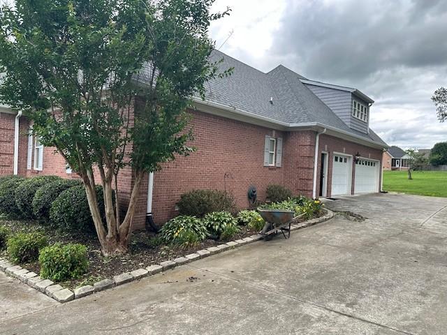106 Rigney Rd, Manchester, TN 37355 - view of property exterior with concrete driveway, brick siding, and a shingled roof