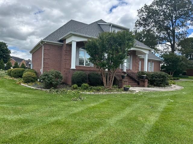 106 Rigney Rd, Manchester, TN 37355 - view of home's exterior featuring a lawn, brick siding, and roof with shingles
