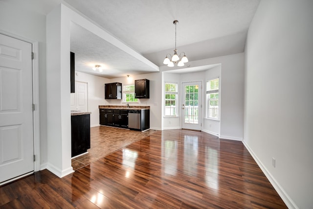 210 Apache Trl, White House, TN 37188 - unfurnished living room featuring dark wood finished floors, a chandelier, baseboards, and a sink