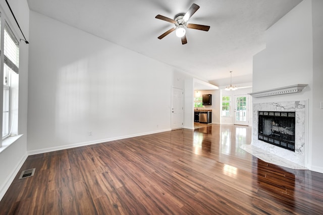 210 Apache Trl, White House, TN 37188 - unfurnished living room featuring wood finished floors, a ceiling fan, a fireplace, a chandelier, and baseboards