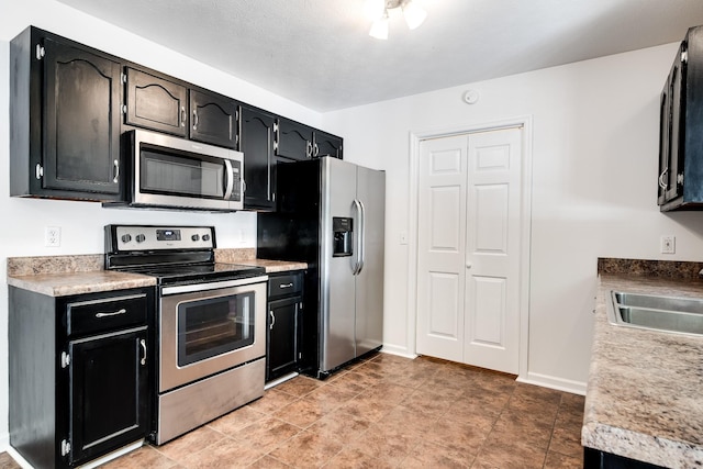 210 Apache Trl, White House, TN 37188 - kitchen with stainless steel appliances, dark cabinetry, a sink, and light countertops