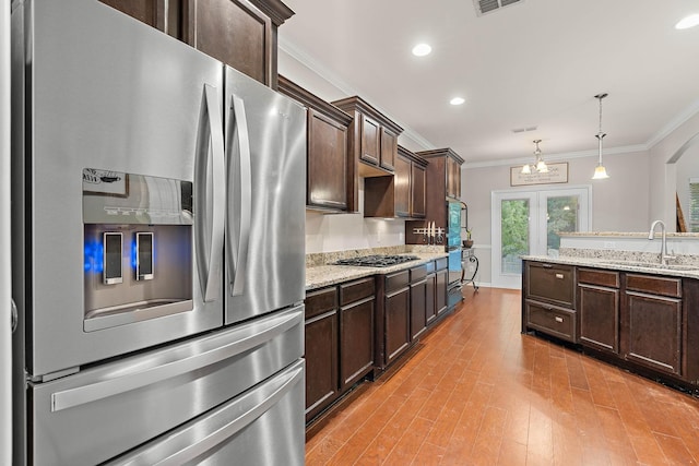 2034 Lincoln Rd, Spring Hill, TN 37174 - kitchen featuring appliances with stainless steel finishes, ornamental molding, a sink, dark brown cabinetry, and light wood-style floors