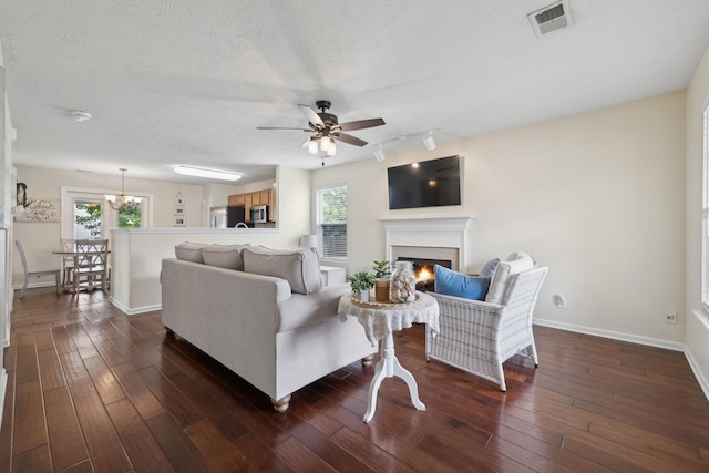 4641 Cather Ct, Nashville, TN 37214 - living room with a lit fireplace, a ceiling fan, track lighting, dark wood-type flooring, and a textured ceiling