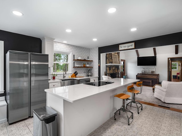 2521 Greens Mill Rd, Columbia, TN 38401 - kitchen with freestanding refrigerator, a sink, a breakfast bar area, light countertops, and black electric cooktop