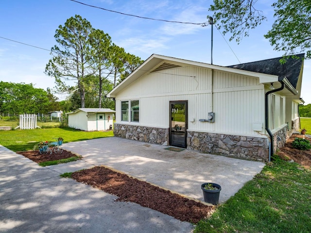 2521 Greens Mill Rd, Columbia, TN 38401 - back of house with stone siding, a patio area, and a lawn