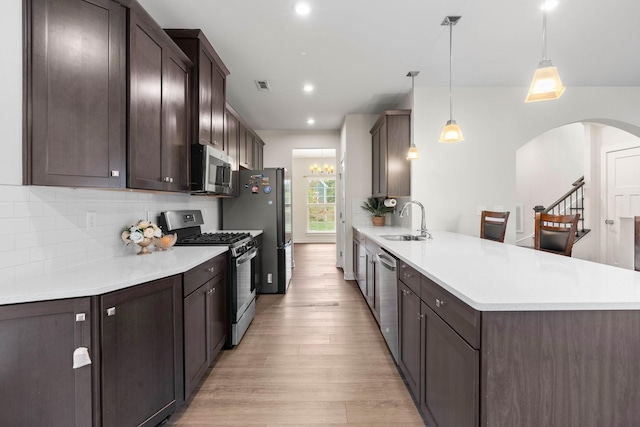 8061 Warbler Way, Brentwood, TN 37027 - kitchen with appliances with stainless steel finishes, a sink, arched walkways, light wood-type flooring, and dark brown cabinets