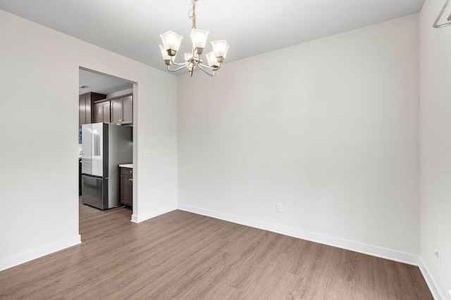 8061 Warbler Way, Brentwood, TN 37027 - empty room with a chandelier, wood finished floors, and baseboards
