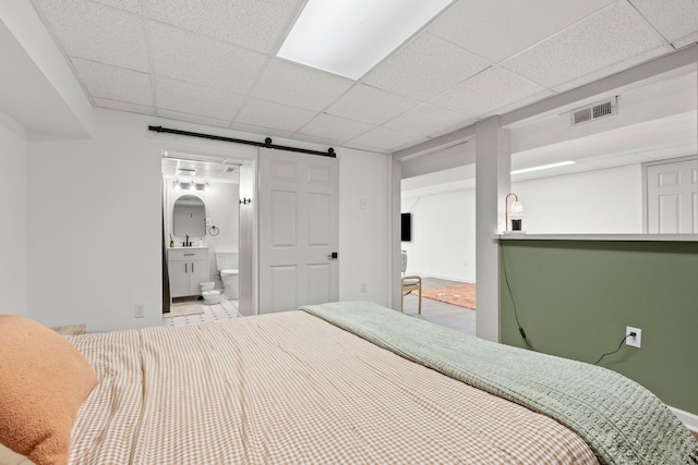 301 Tyler Dr, Hermitage, TN 37076 - bedroom featuring a barn door, a drop ceiling, baseboards, and ensuite bathroom