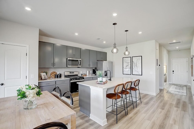 5053 Lawler Ln, Old Hickory, TN 37138 - kitchen with stainless steel appliances, gray cabinetry, light countertops, a center island with sink, and recessed lighting