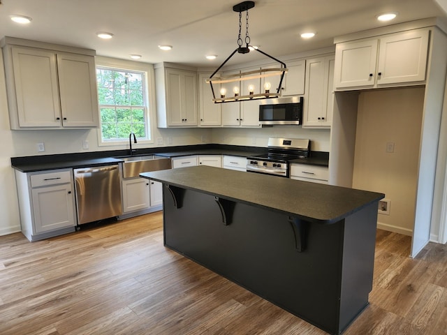 524 Pleasant Hill Rd, Lafayette, TN 37083 - kitchen with appliances with stainless steel finishes, dark countertops, a sink, a center island, and a breakfast bar area