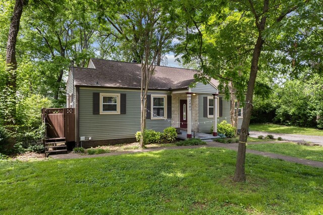 2401 Vaulx Ln, Nashville, TN 37204 - view of front of house featuring a front yard, roof with shingles, and a deck