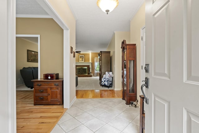 3615 Legacy Dr, Springfield, TN 37172 - entryway with light wood-type flooring, a fireplace with raised hearth, and crown molding