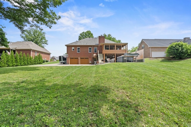 3615 Legacy Dr, Springfield, TN 37172 - rear view of house featuring a garage, a sunroom, a chimney, driveway, and brick siding