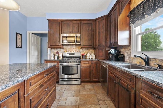 3615 Legacy Dr, Springfield, TN 37172 - kitchen with appliances with stainless steel finishes, stone finish floors, decorative backsplash, and a sink