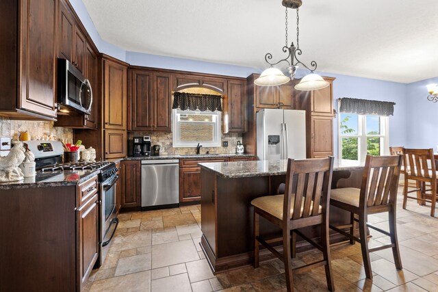 3615 Legacy Dr, Springfield, TN 37172 - kitchen with appliances with stainless steel finishes, a sink, a chandelier, tasteful backsplash, and a kitchen island