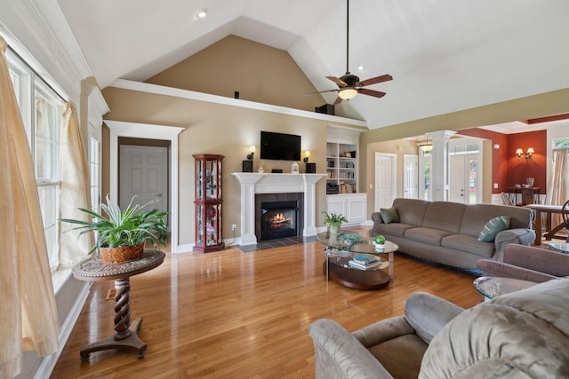 4322 Thoroughbred Ln, Murfreesboro, TN 37127 - living room featuring ceiling fan, a tiled fireplace, ornate columns, wood finished floors, and high vaulted ceiling