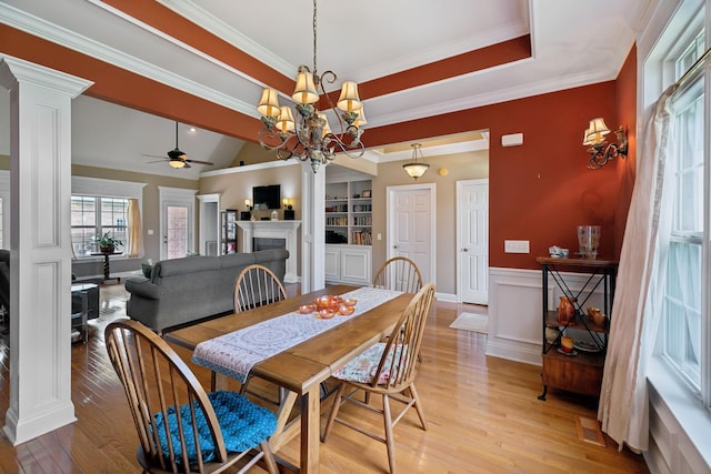 4322 Thoroughbred Ln, Murfreesboro, TN 37127 - dining space with decorative columns, ceiling fan, a fireplace, light wood-style flooring, and a wainscoted wall