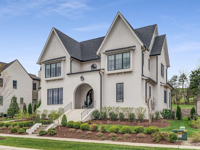 9021 Passiflora Ct, College Grove, TN 37046 - french country home featuring brick siding, a shingled roof, and stairs