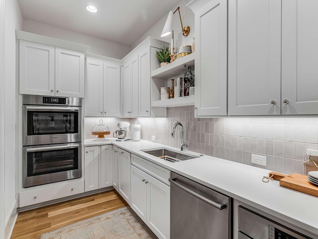 9021 Passiflora Ct, College Grove, TN 37046 - kitchen with appliances with stainless steel finishes, a sink, open shelves, light wood finished floors, and light countertops
