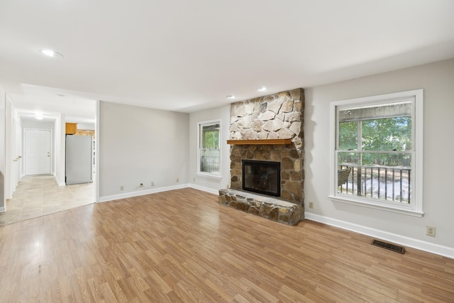 3031 Hartford Dr, Murfreesboro, TN 37129 - unfurnished living room featuring baseboards, light wood-style flooring, a stone fireplace, and recessed lighting