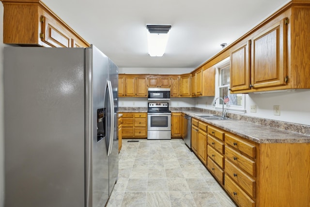 3031 Hartford Dr, Murfreesboro, TN 37129 - kitchen with stainless steel appliances, a sink, brown cabinets, and stone finish floors