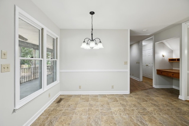 3031 Hartford Dr, Murfreesboro, TN 37129 - unfurnished dining area featuring stone finish flooring, a chandelier, and baseboards