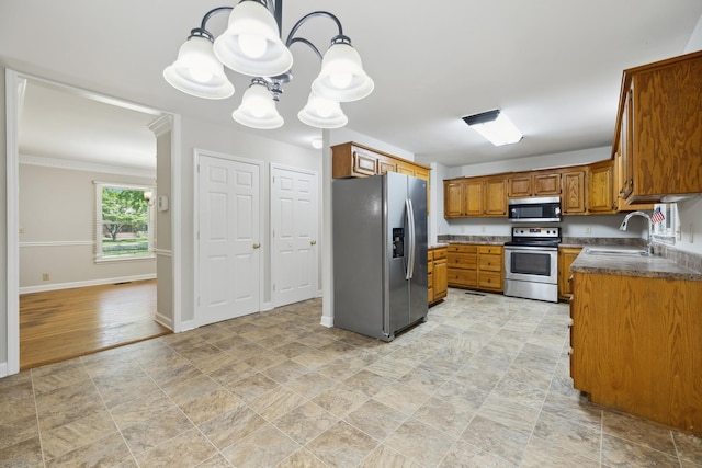 3031 Hartford Dr, Murfreesboro, TN 37129 - kitchen featuring appliances with stainless steel finishes, brown cabinetry, a chandelier, a sink, and stone finish flooring