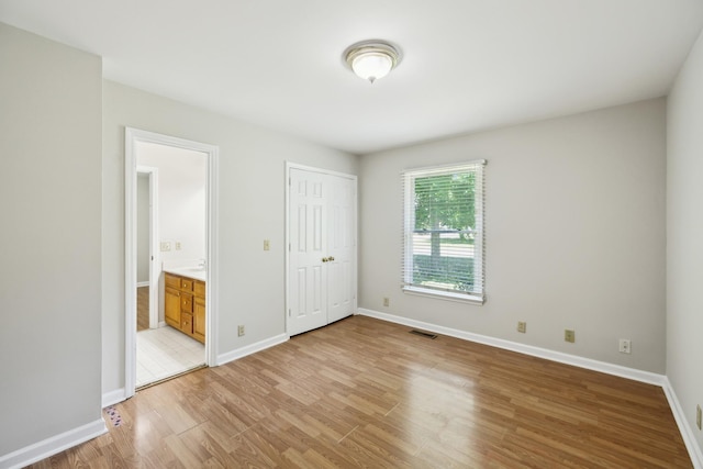 3031 Hartford Dr, Murfreesboro, TN 37129 - unfurnished bedroom featuring light wood-style flooring, baseboards, connected bathroom, and a closet