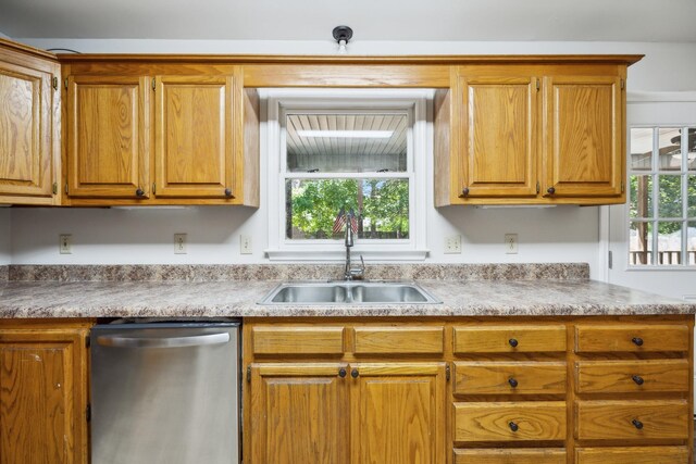 3031 Hartford Dr, Murfreesboro, TN 37129 - kitchen with stainless steel dishwasher, a sink, light countertops, and brown cabinets