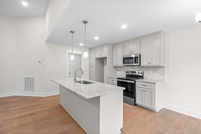 1928 Flats Rd, Cunningham, TN 37052 - kitchen featuring stainless steel appliances, a sink, light wood-style floors, baseboards, and decorative backsplash