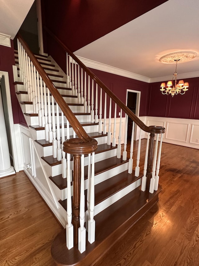 95 Dundee Cir, Mcminnville, TN 37110 - staircase with a decorative wall, crown molding, a chandelier, wood finished floors, and a wainscoted wall