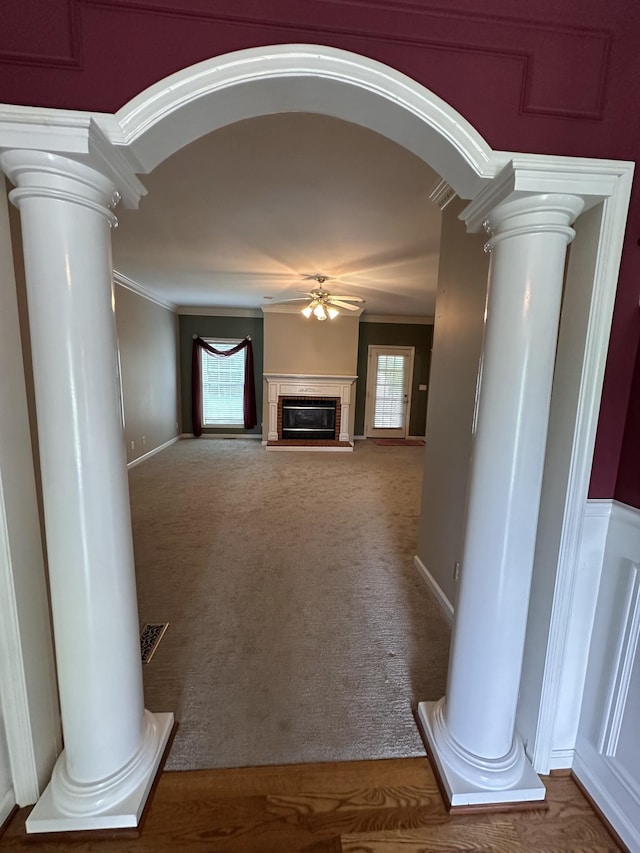 95 Dundee Cir, Mcminnville, TN 37110 - unfurnished living room featuring decorative columns, ceiling fan, healthy amount of natural light, a glass covered fireplace, and crown molding
