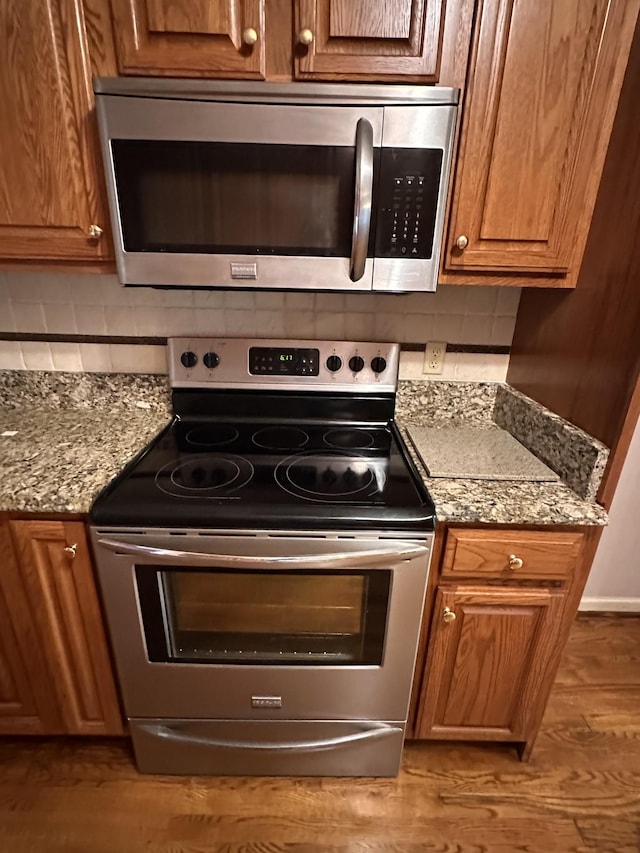 95 Dundee Cir, Mcminnville, TN 37110 - kitchen with stainless steel appliances, tasteful backsplash, brown cabinetry, wood finished floors, and light stone counters