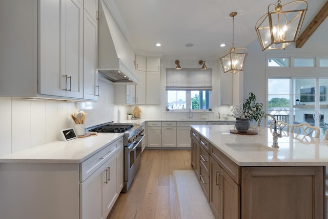 4761 Woodrow Pl, Arrington, TN 37014 - kitchen featuring double oven range, a sink, premium range hood, light wood finished floors, and a center island with sink