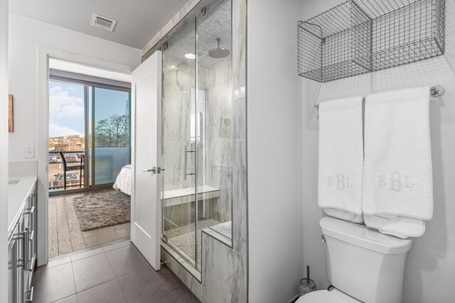 1212 Laurel St Unit 206, Nashville, TN 37203 - ensuite bathroom featuring a shower stall, vanity, toilet, and tile patterned floors