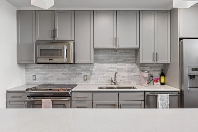 1212 Laurel St Unit 206, Nashville, TN 37203 - kitchen with stainless steel appliances, a sink, gray cabinetry, and tasteful backsplash
